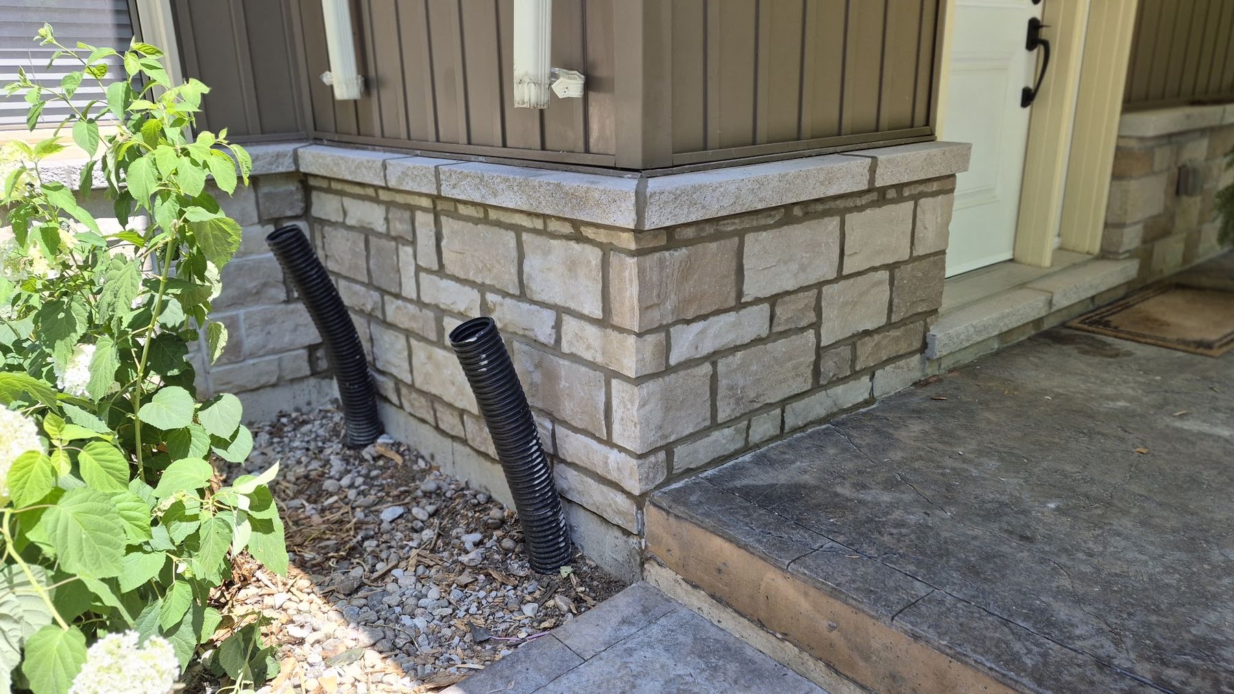 The same house corner with its stone veneer reinstalled
